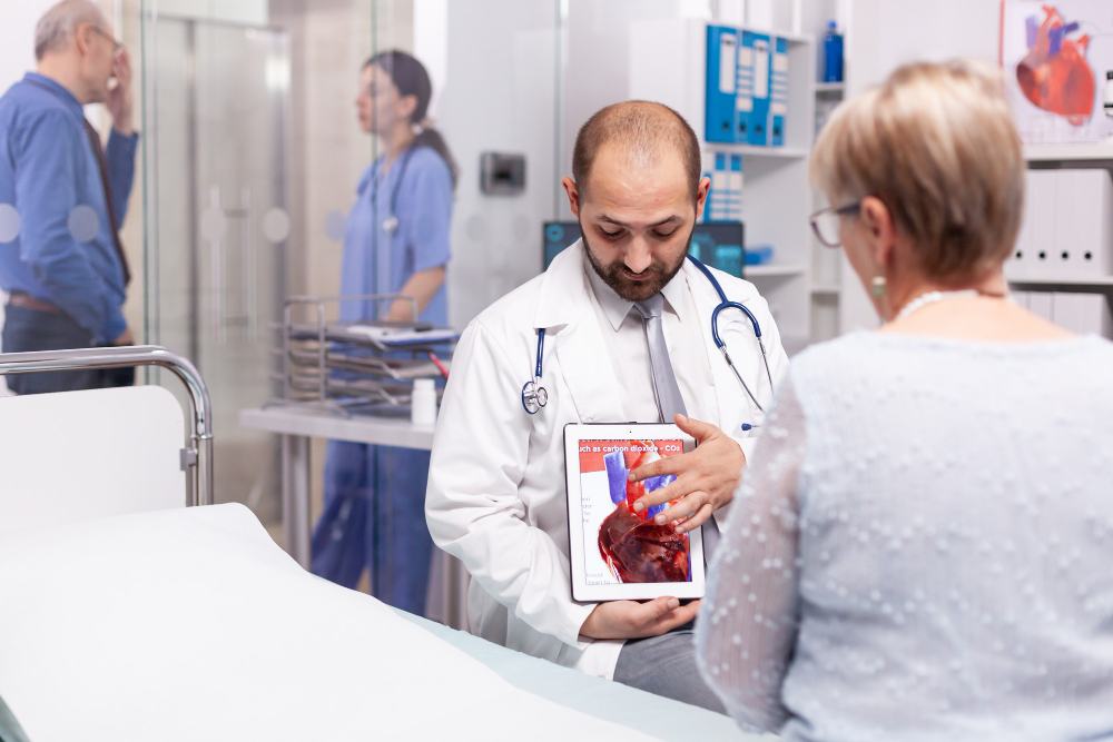 Doctor explaining heart images on a tablet to a patient